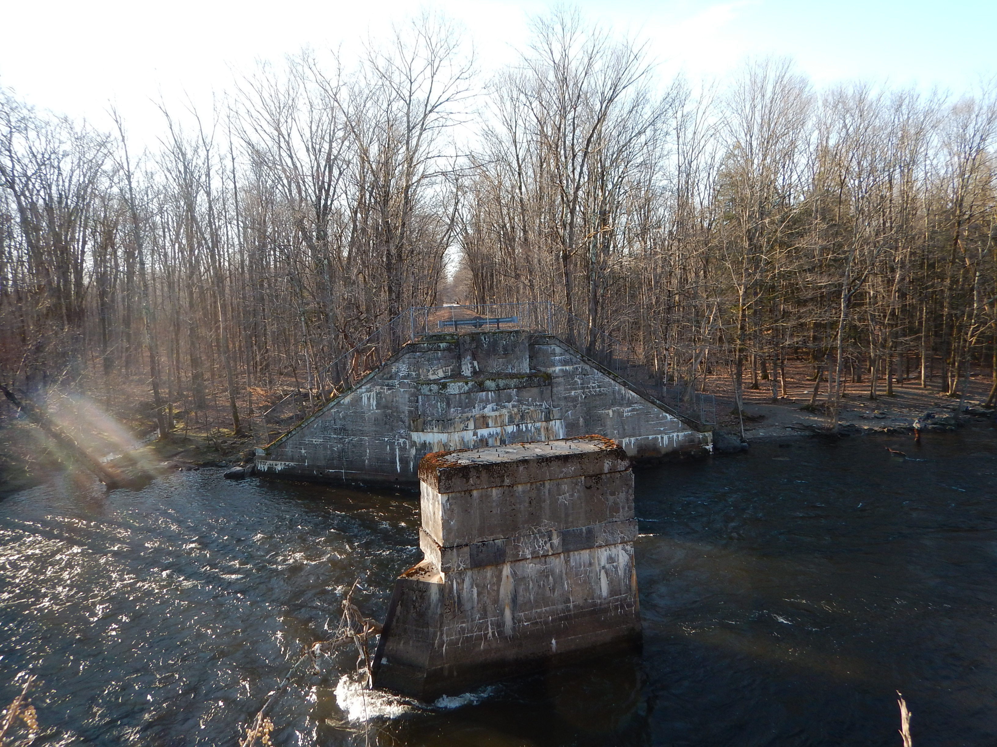 View of a river with a bridge support in the middle and on the far side, but no bridge across.